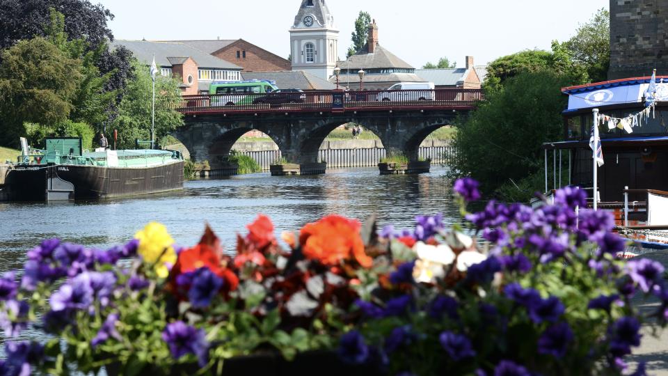 Newark bridge with a boat sailing on the river